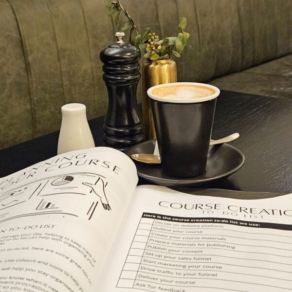 The Course Creation Guidebook To Create That Course sits on a table.