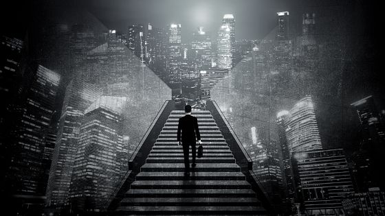 A man is walking up a set of stairs in a dark city.