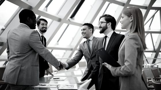 A group of business people shaking hands in a conference room.