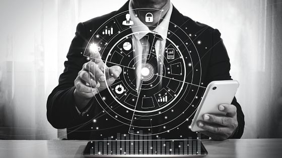 A businessman in a suit is holding a tablet with an icon on it.